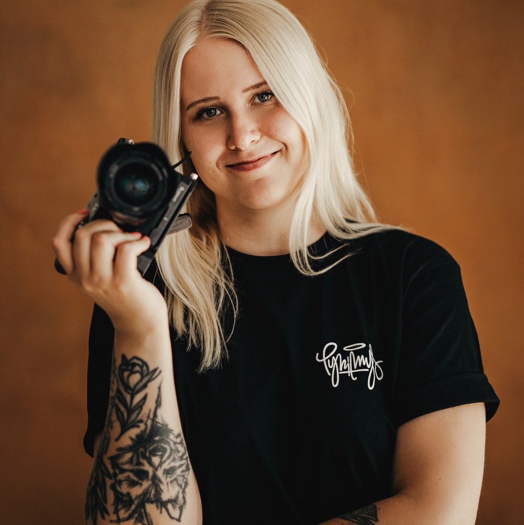 Kuvassa valokuvaaja Jonna Helin pitää kädessään järjestelmäkameraa